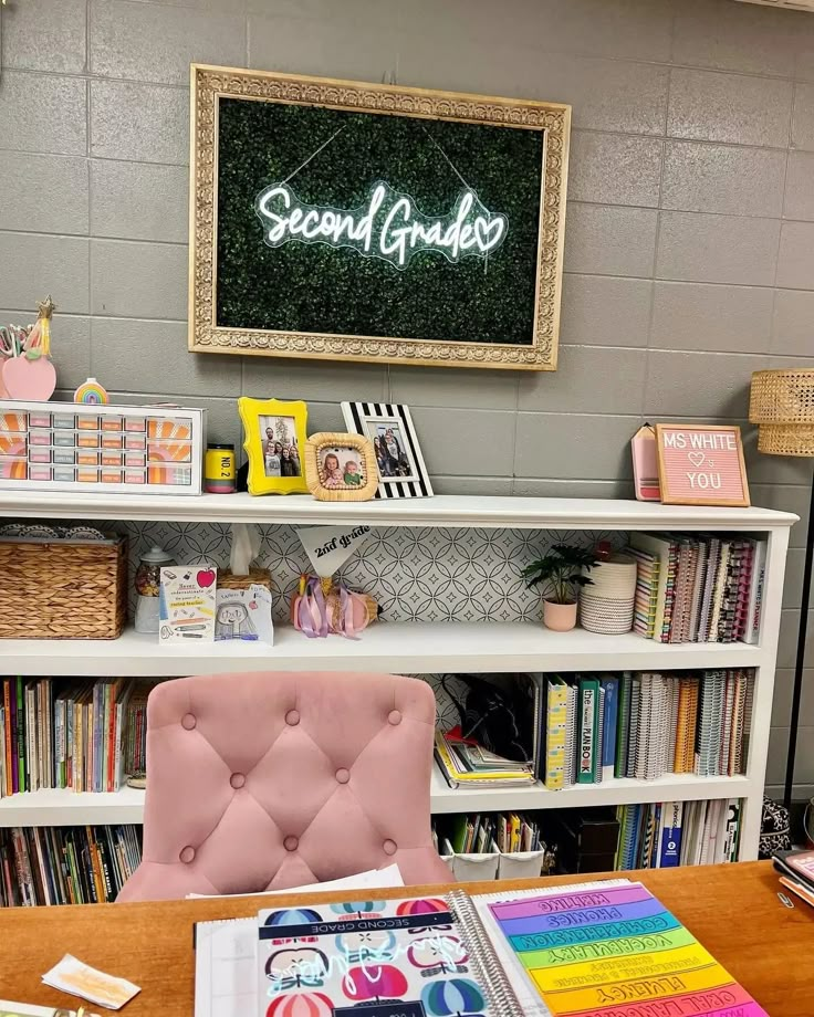 there is a book shelf with books on it and a pink chair in front of it