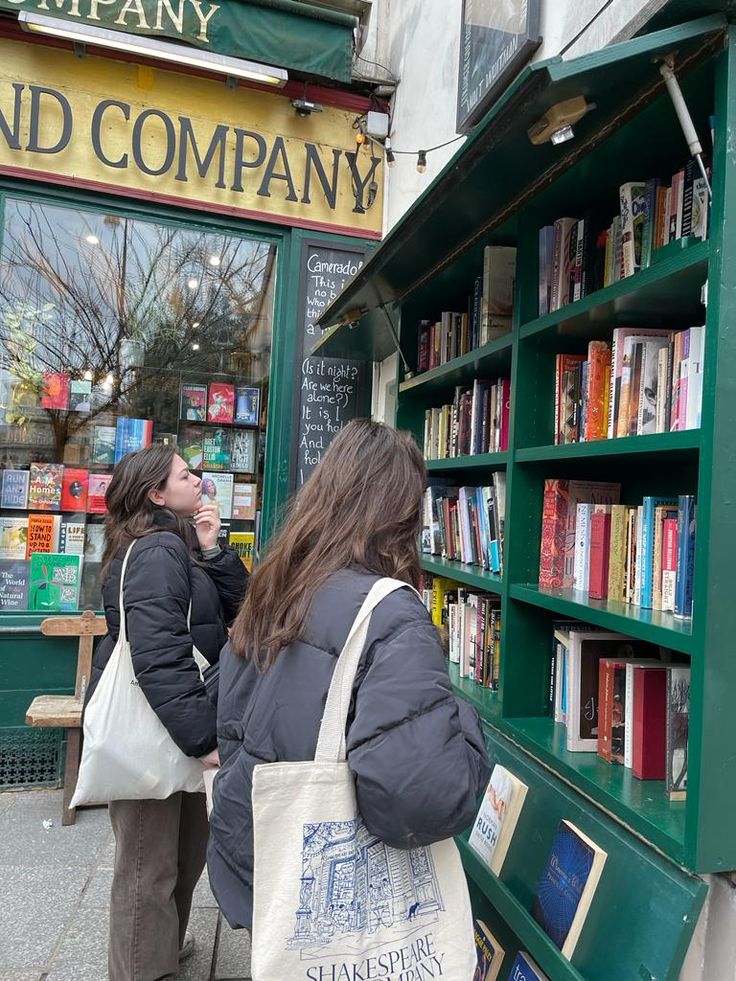 two women are looking at books on the shelves in front of a book store,