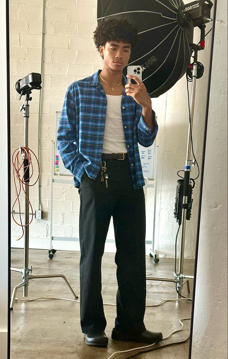 a man standing in front of a mirror holding a cell phone