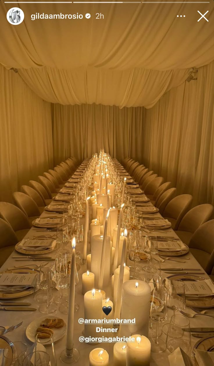 a long table is set with candles and place settings for an event or dinner party