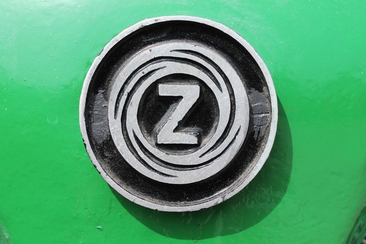 the letter z is on the side of a green truck's front wheel hub