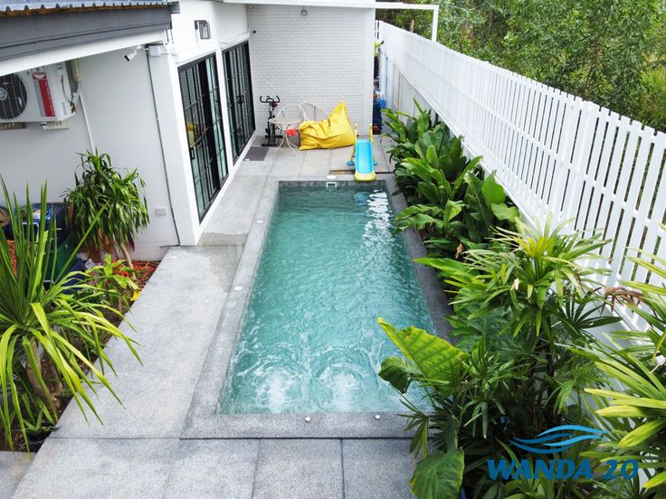 a small swimming pool surrounded by plants and trees