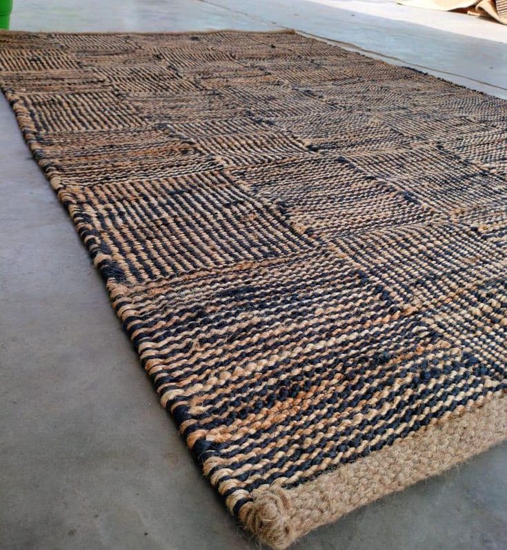 an old rug is laying on the floor in front of a green potted plant