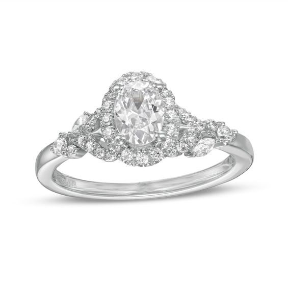 a white gold ring with an oval cut diamond surrounded by smaller round diamonds on the band