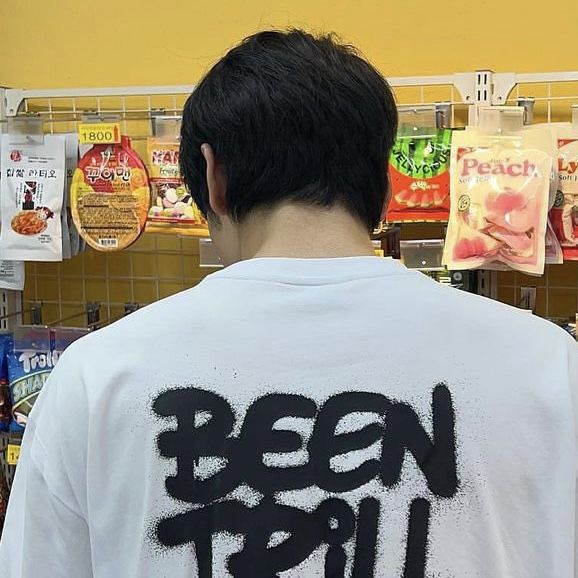 a man wearing a white shirt with the words been fruit on it in black ink