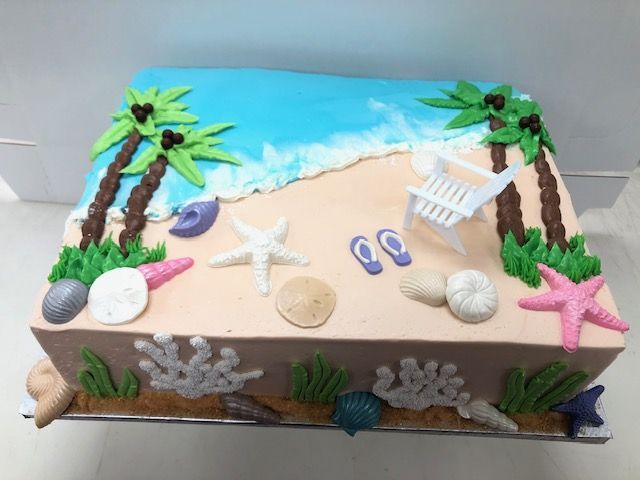 a cake decorated with beach scenes and seashells