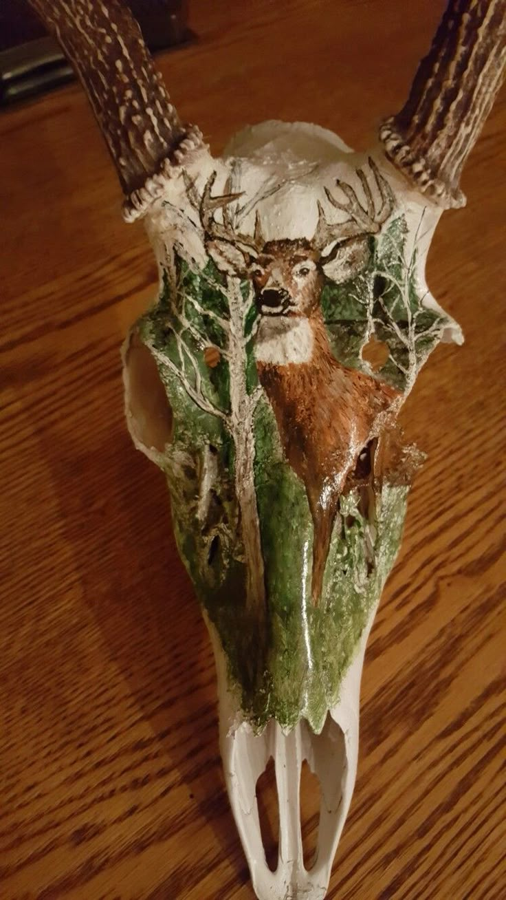 a deer's skull with antlers on top of it sitting on a wooden table