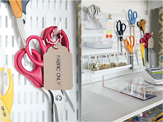 there are many pairs of scissors hanging on the pegs in this crafting room