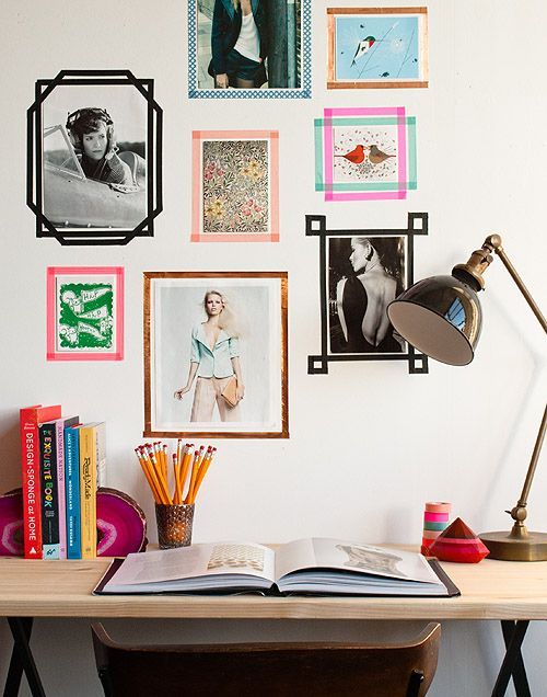 a desk with books, magazines and pictures on the wall