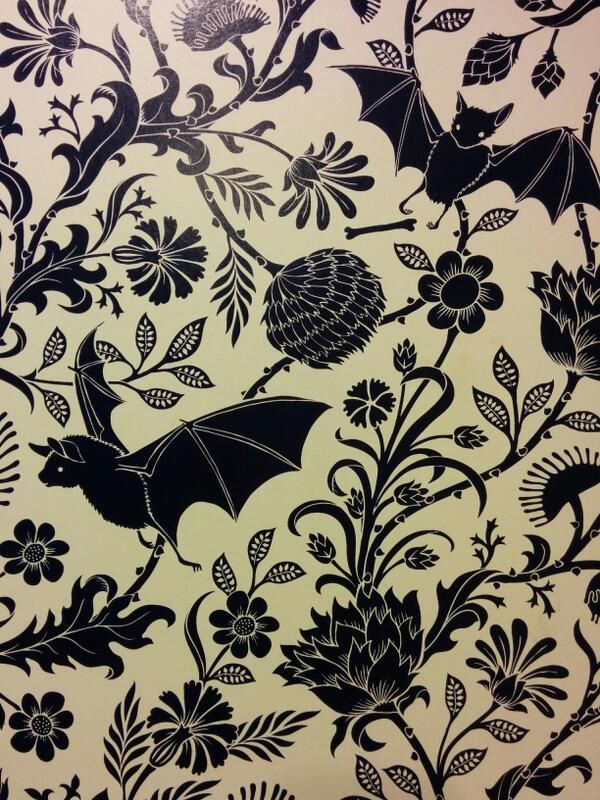 an image of a bat and flowers on a wallpaper pattern in black and white