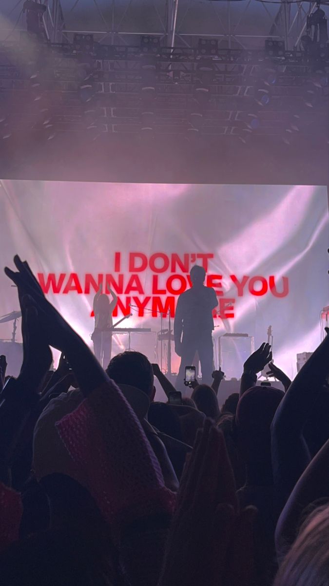 a man standing on top of a stage with his hands in the air