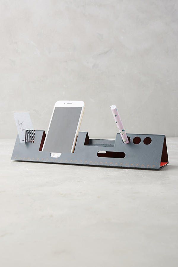 a cell phone and pen holder on a table