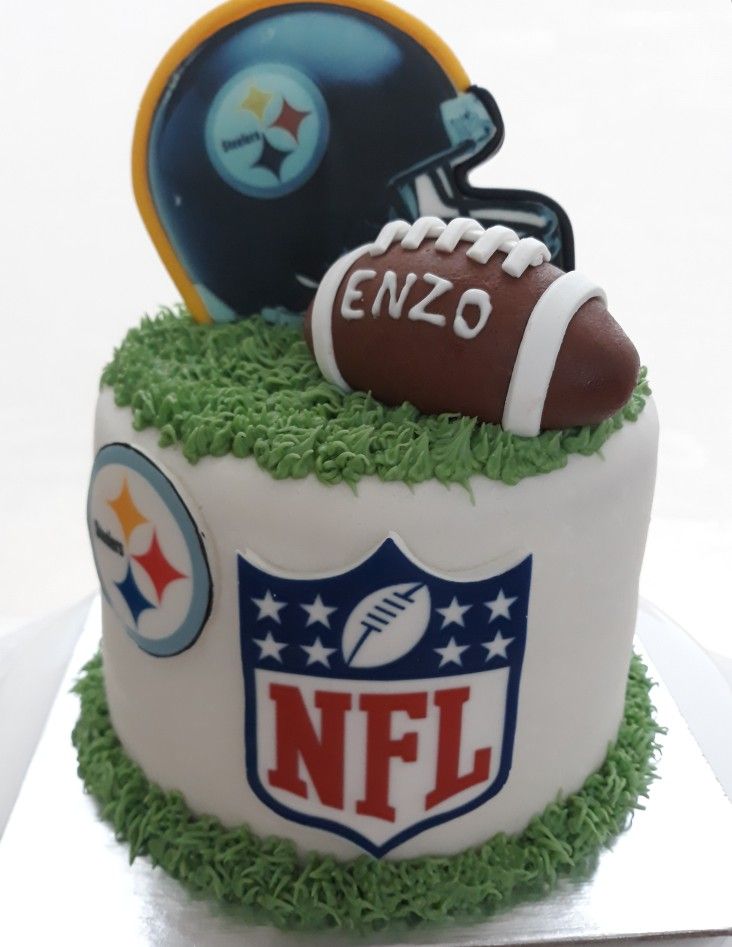 a birthday cake with a football helmet and ball on top is decorated to look like the nfl logo