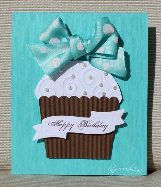 a birthday card with a cupcake on it and a blue ribbon around the top