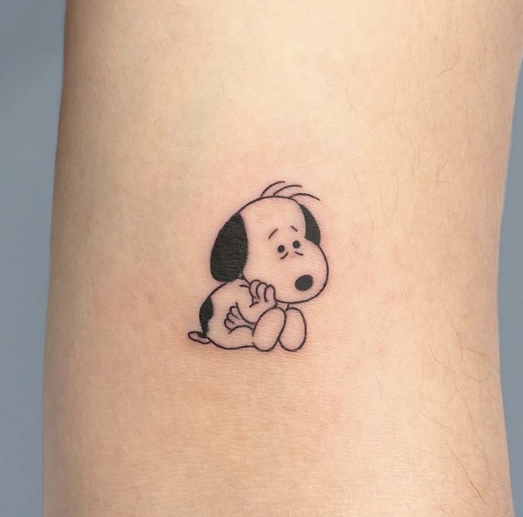 a small cartoon dog tattoo on the ankle