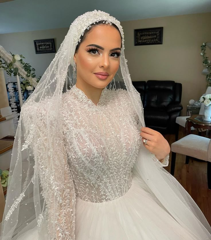 a woman in a wedding dress is posing for the camera with her veil draped over her head