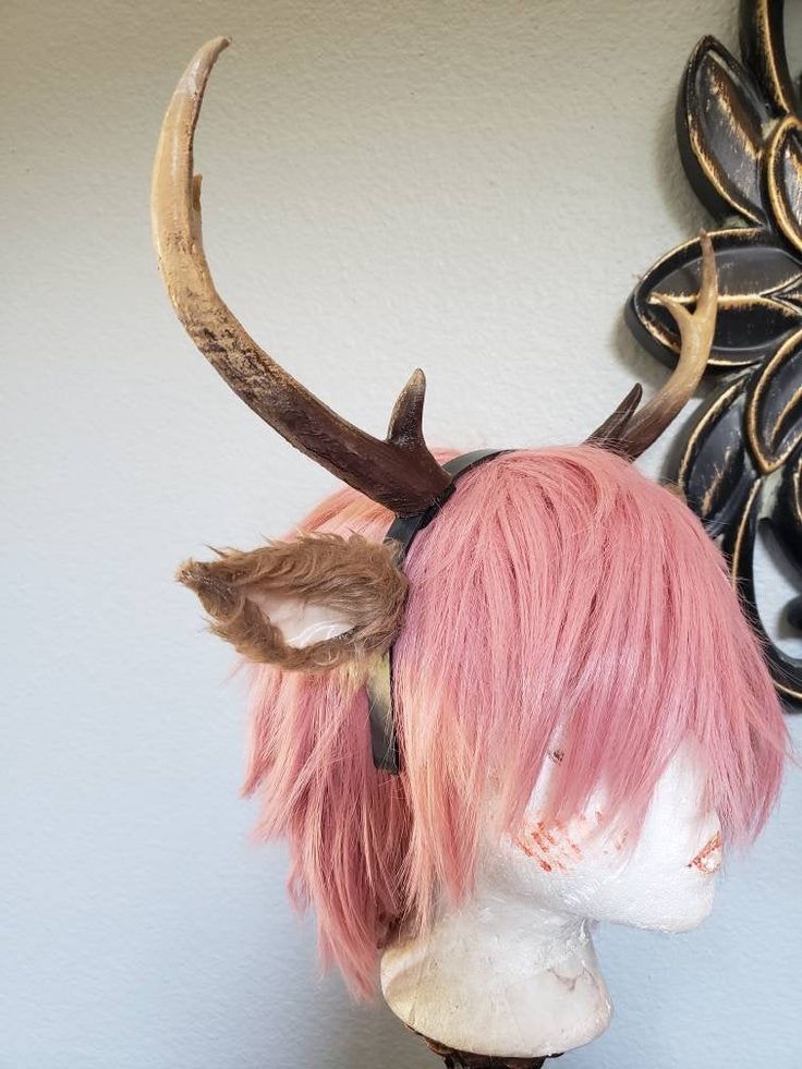 a pink wig with horns on top of a mannequin's head