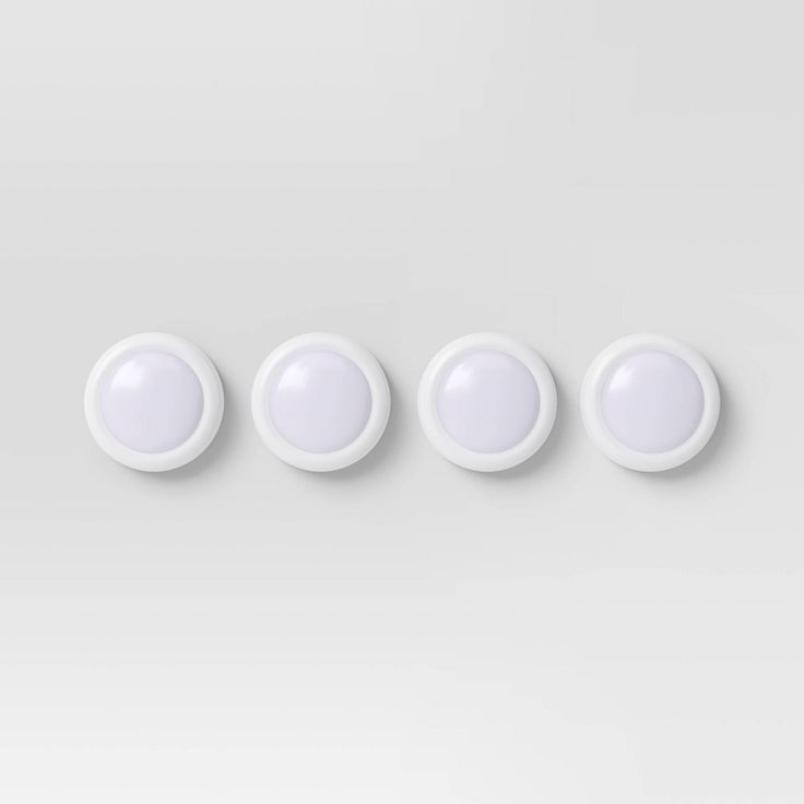 three white round lights are shown on a gray background, and the third one is off to the side