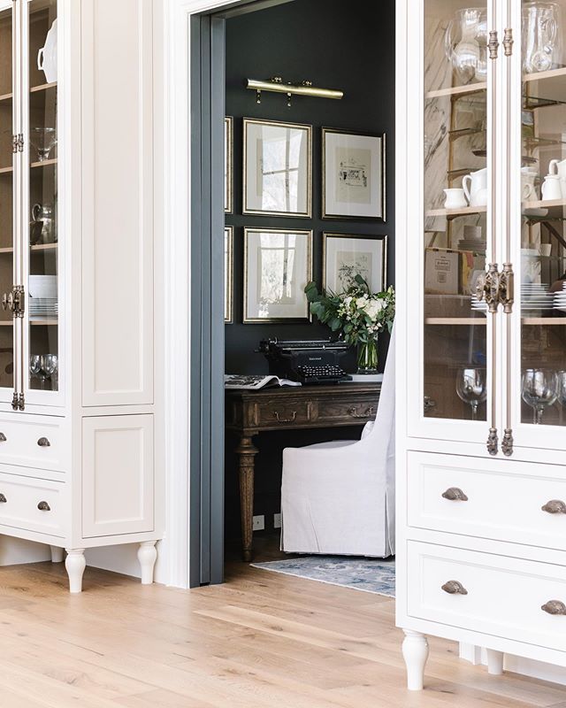 a white china cabinet with glass doors and drawers