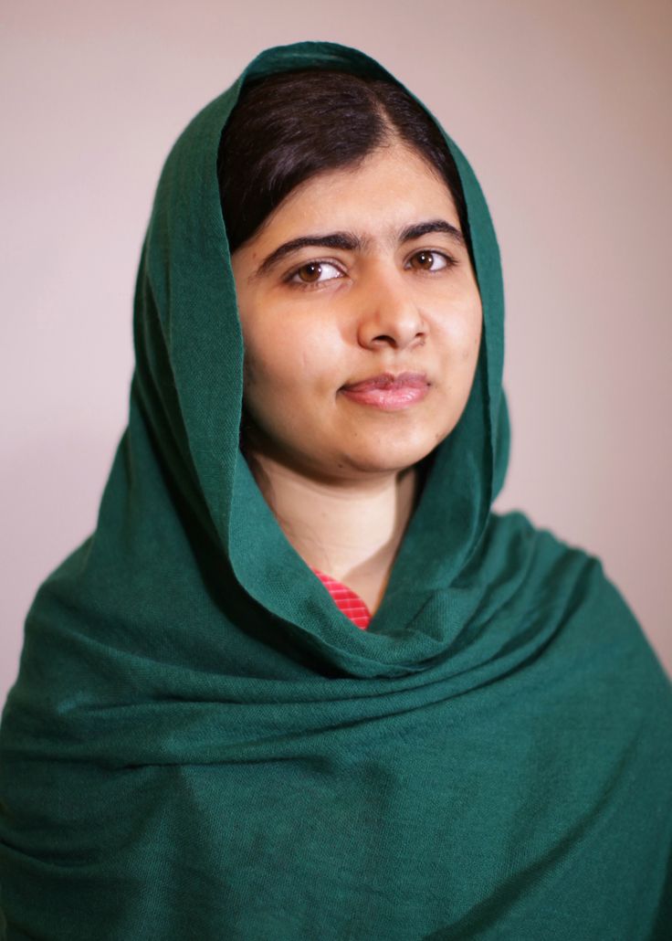 a woman wearing a green shawl looking at the camera