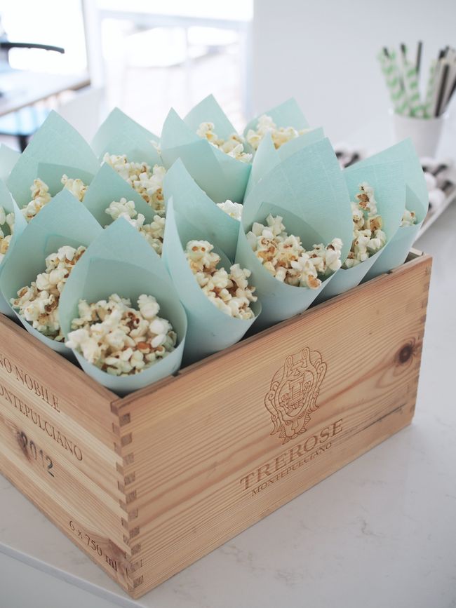 a wooden box filled with popcorn sitting on top of a counter