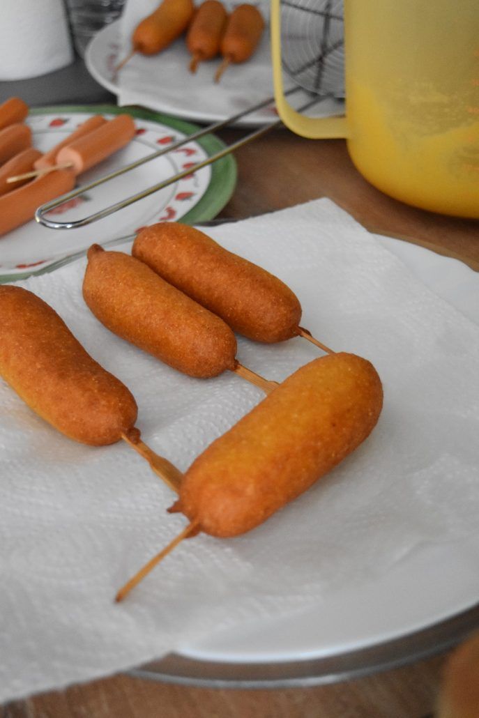 four hot dogs are being cooked on a plate with toothpicks stuck in them