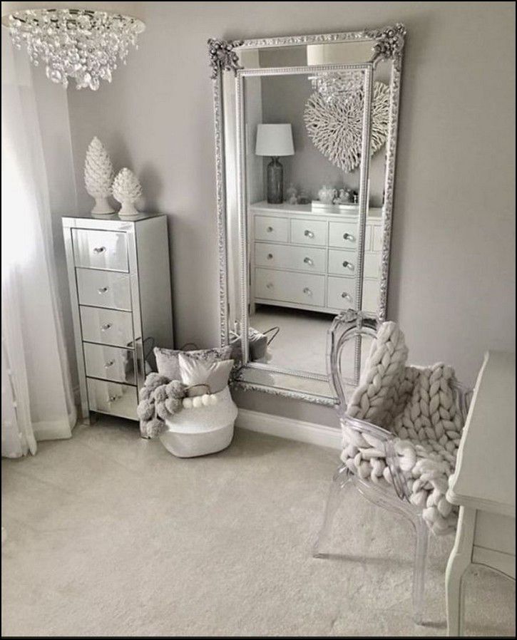 a bedroom with a large mirror and white furniture