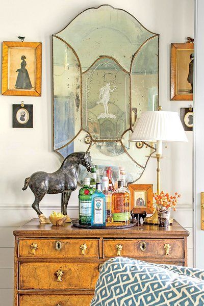 an antique dresser with decorative items on it and a horse statue sitting on the top