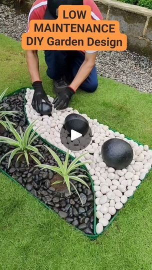 a man kneeling down next to a garden design with rocks and stones on it,