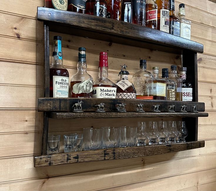 a shelf filled with bottles and glasses on top of a wooden wall