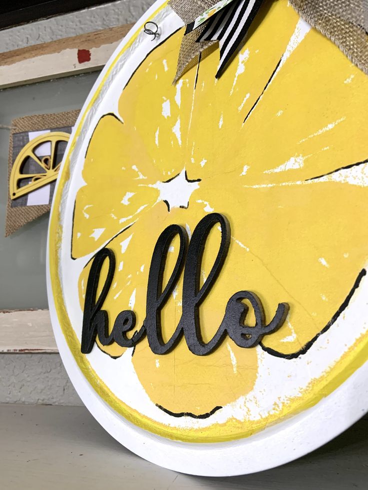 a yellow and white plate with the word hello painted on it's front side