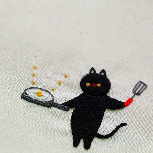 a black cat holding a frying pan with an egg on it's side