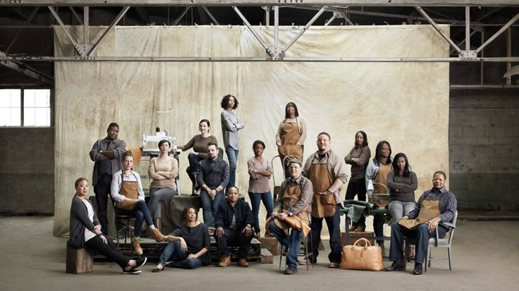 a group of people standing and sitting in front of a wall