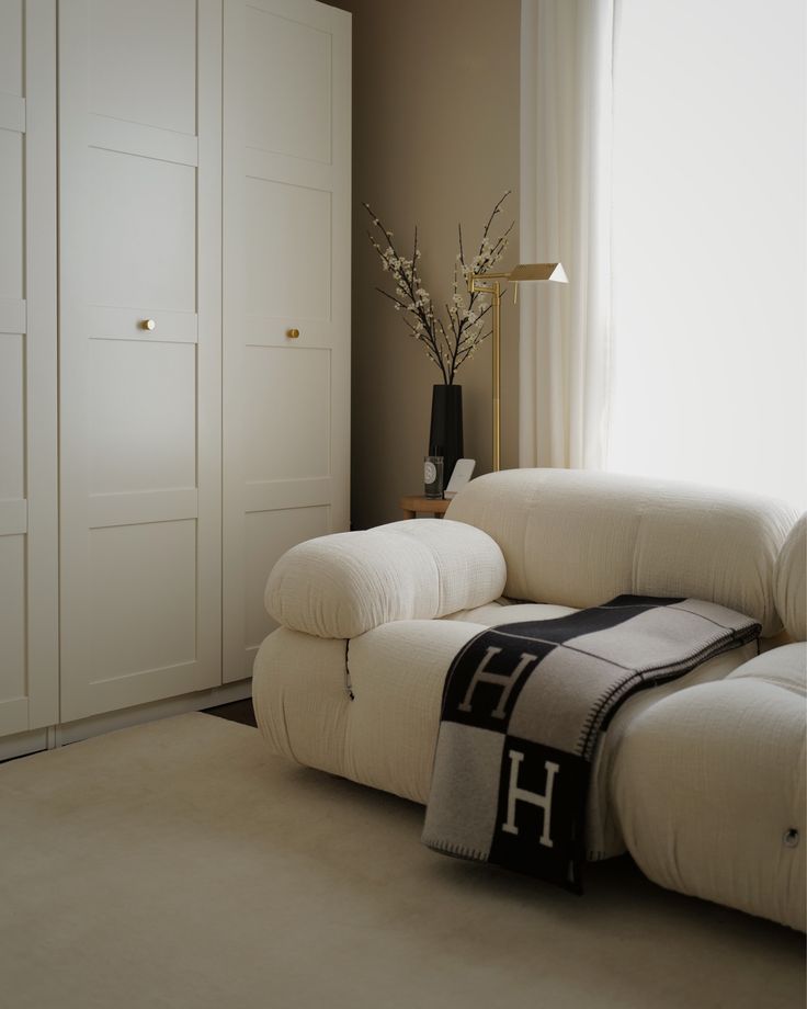 a living room with a white couch and large window