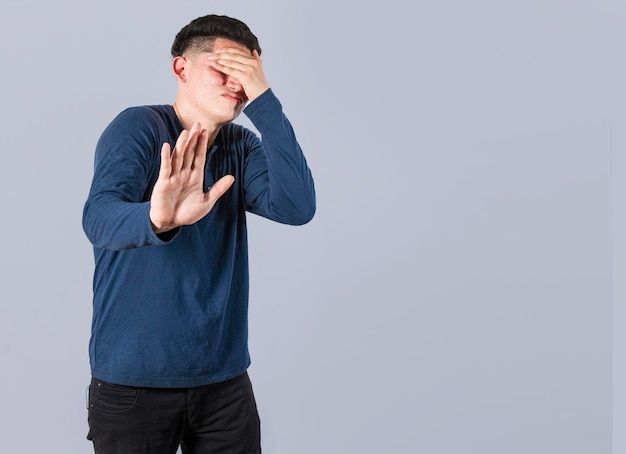 a man is covering his eyes with his hands