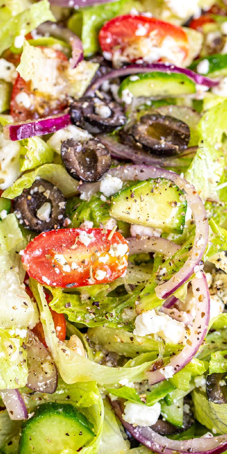 a salad with olives, tomatoes, onions and feta cheese