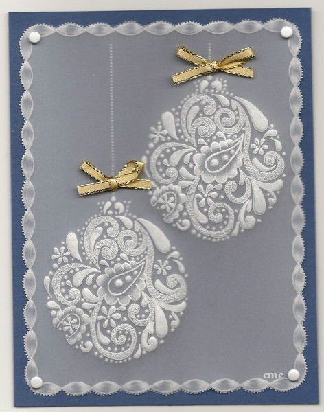 two white christmas balls with gold bows on them are hanging from a blue and silver card