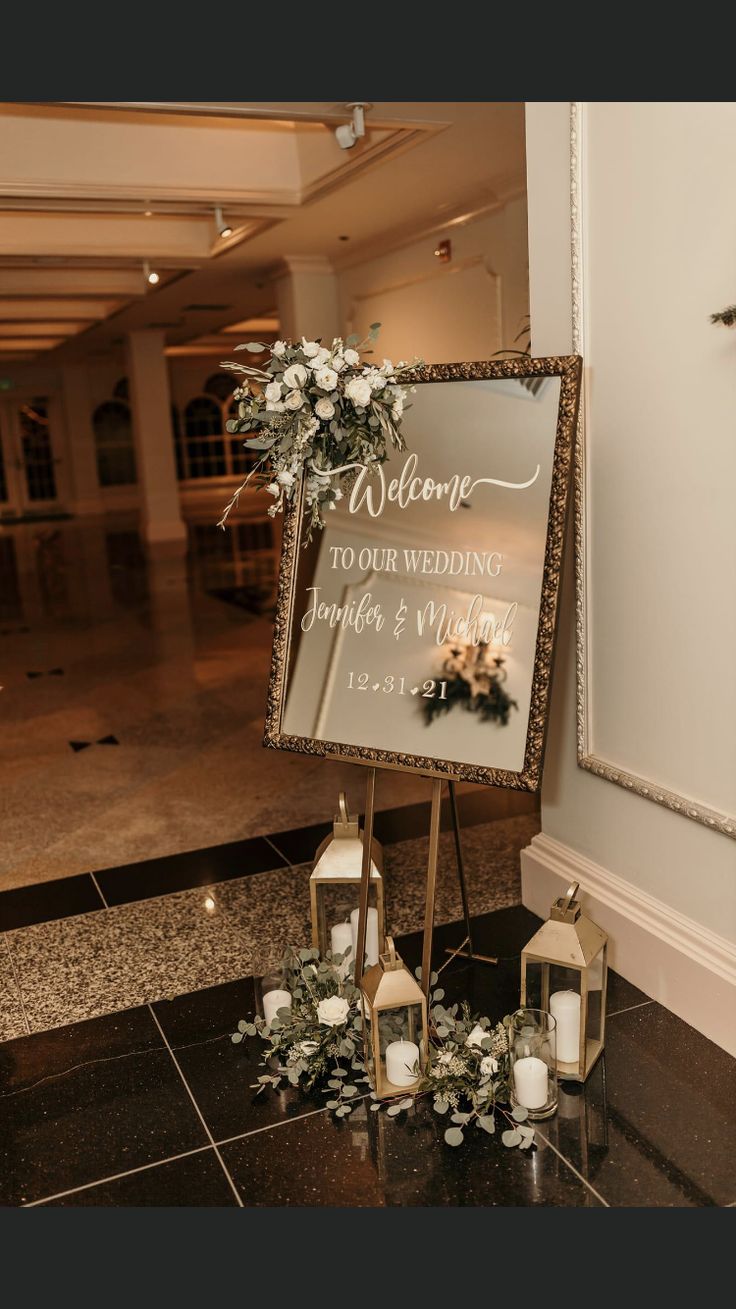 a welcome sign with flowers and candles on the floor