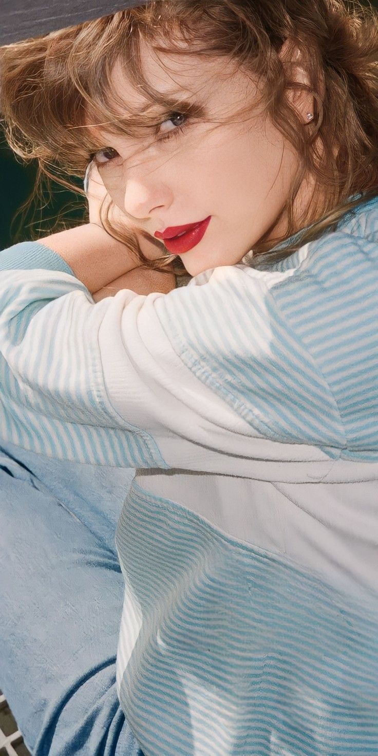 a woman with red lipstick sitting on the ground