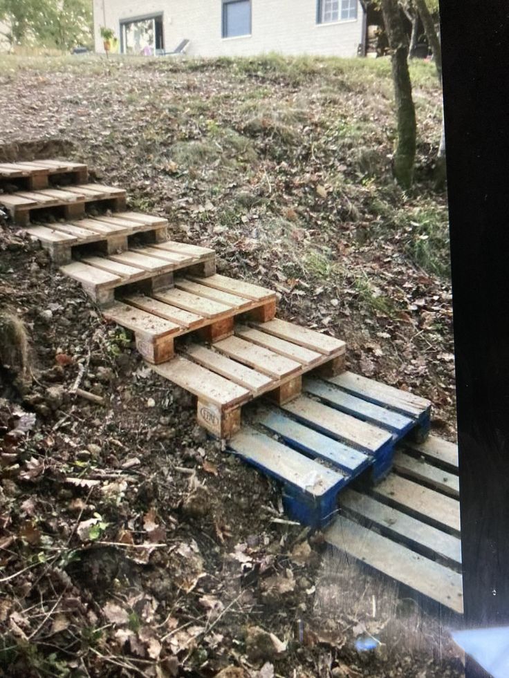 there are wooden steps going up the hill in the yard with no one on it