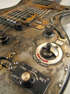 an old, dirty electric guitar with some knobs and wires attached to it's body