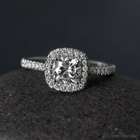 a cushion cut diamond ring on top of a rock