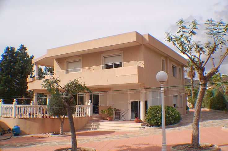 an apartment building with palm trees in the front yard and stairs leading up to it