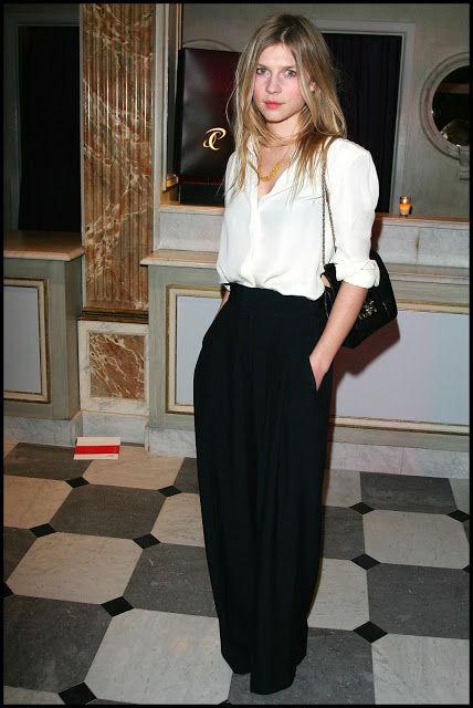 a woman standing on a checkered floor wearing black and white