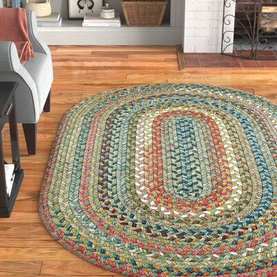 a living room area with a rug on the floor and a chair next to it