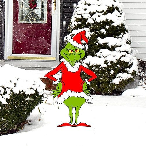 an image of the grin face on top of a christmas tree in front of a house