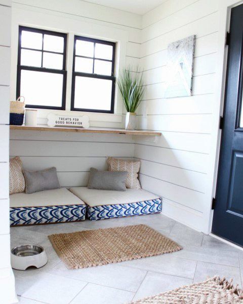 a dog bed in the corner of a room next to a blue door and window