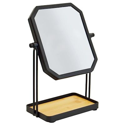 a mirror is sitting on a stand with a wooden tray