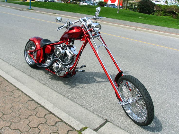 a red motorcycle is parked on the side of the road