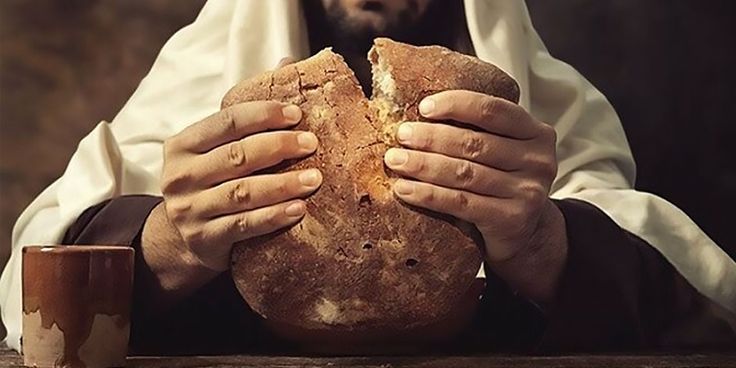 a man holding a large piece of bread in his hands